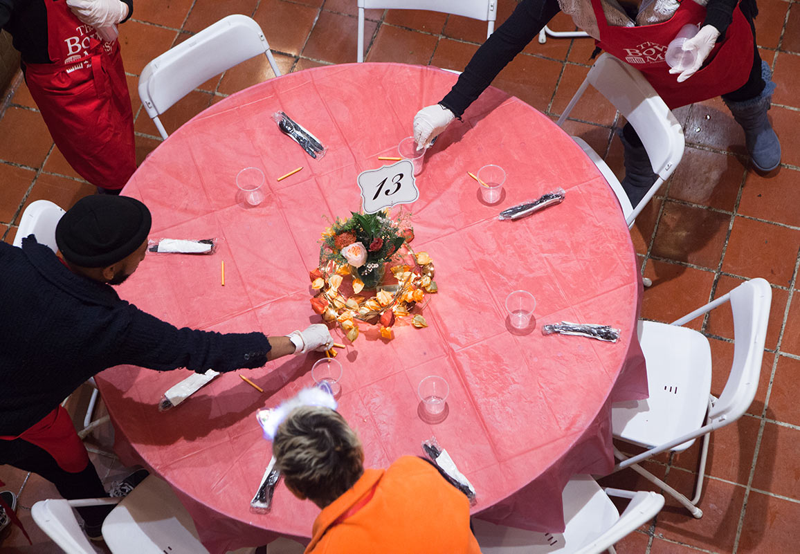 Thanksgiving table being set by volunteers